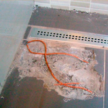 Ukázkový případ, jak se topné kabely nemají pokládat. Po krátké době přestalo podlahové topení v koupelně hřát, po odkrytí dlažby se ukázalo chybné křížení topných kabelů.